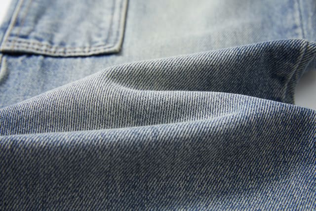 Light-wash denim with hand-finished whiskering and a classic five-pocket front